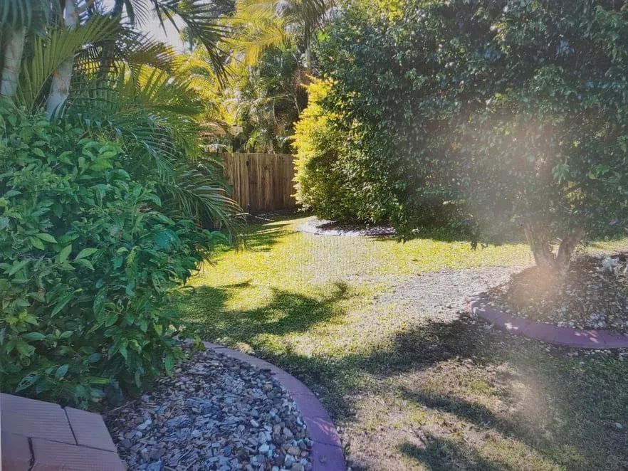 A Picture of a Backyard With a Fence and Trees — Caloundra Landscape Supplies in Caloundra, QLD
