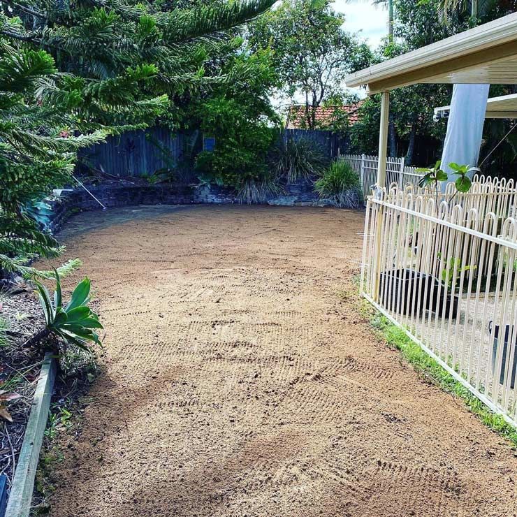 A Dirt Yard With a White Fence and a House in the Background — Caloundra Landscape Supplies in Caloundra, QLD