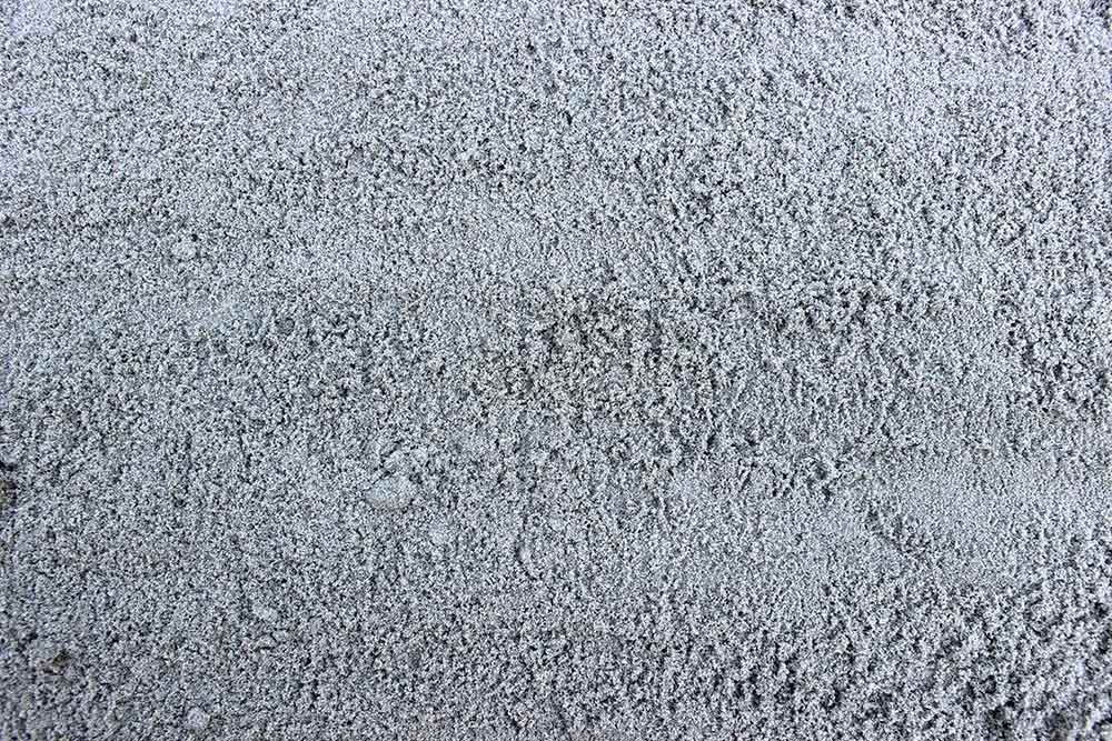 Gray asphalt road surface with horizontal striations.