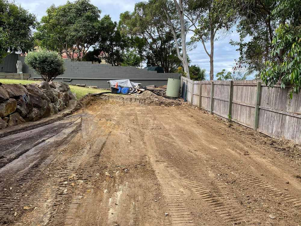 A Dirt Road Leading to a House With a Wooden Fence — Caloundra Landscape Supplies in Caloundra, QLD