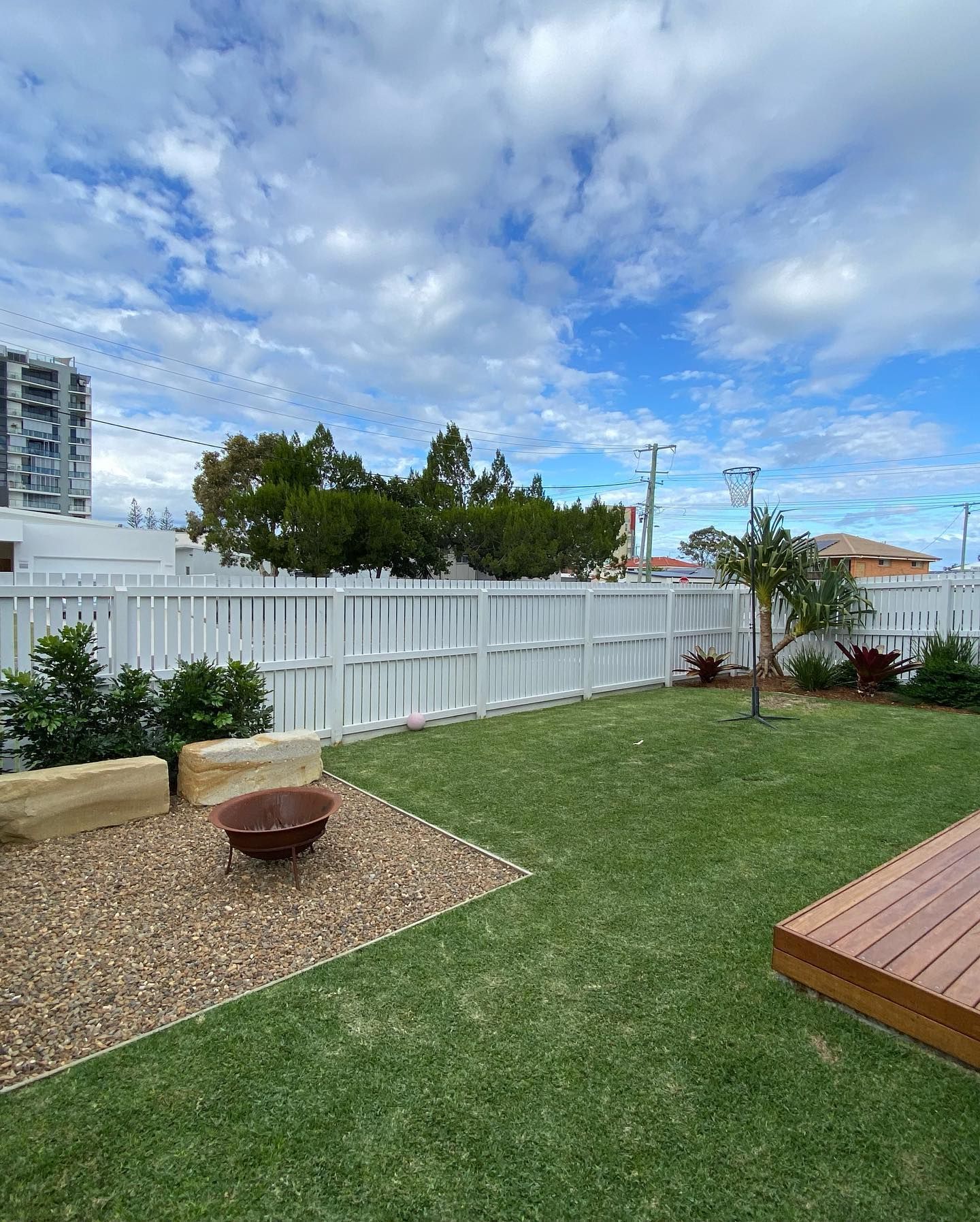 A Backyard With a White Fence and a Fire Pit — Caloundra Landscape Supplies in Caloundra, QLD