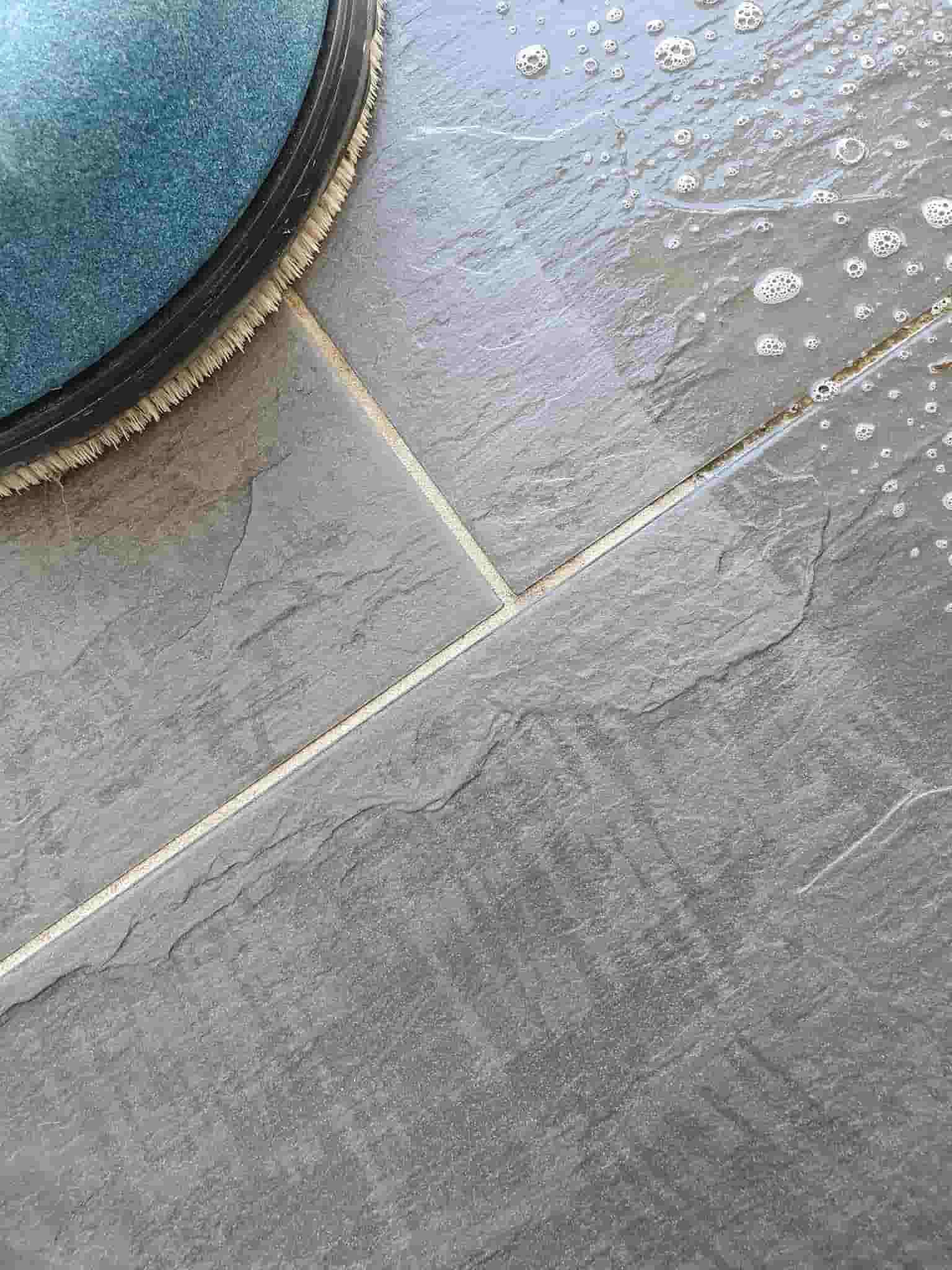 A Close Up of a Tiled Floor With a Brush on It — NQW Services In Cardwell, QLD