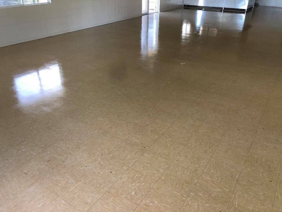 A Large Empty Room With a Tiled Floor and a Window — NQW Services In Townsville, QLD