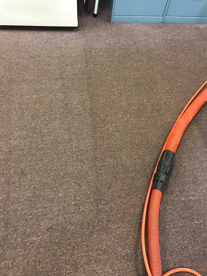 A Large Orange Hose is Sitting on a Brown Carpet — NQW Services In Ayr, QLD