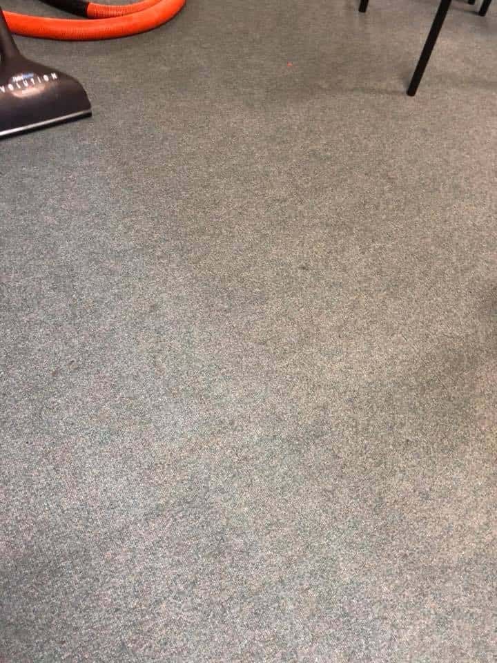 A Vacuum Cleaner is Sitting on a Carpet in a Room — NQW Services In Townsville, QLD