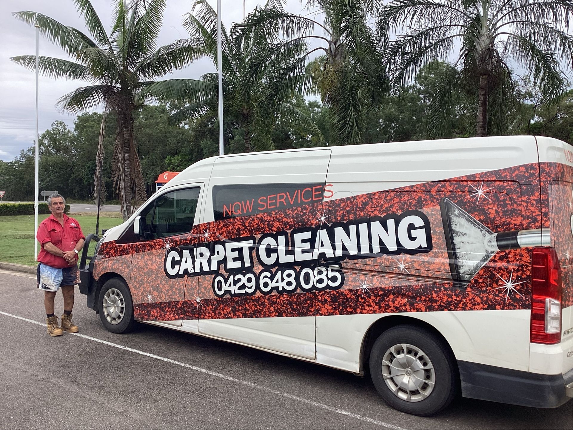 A Man is Standing in Front of a Carpet Cleaning Van — NQW Services In Cardwell, QLD