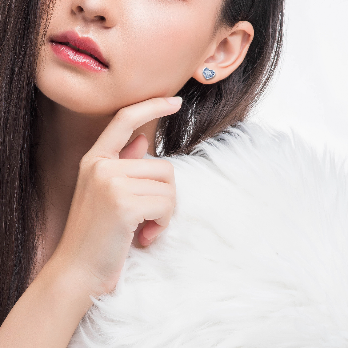 一對銀色心形耳環，鑲嵌著閃亮的透明寶石，背景為白色。