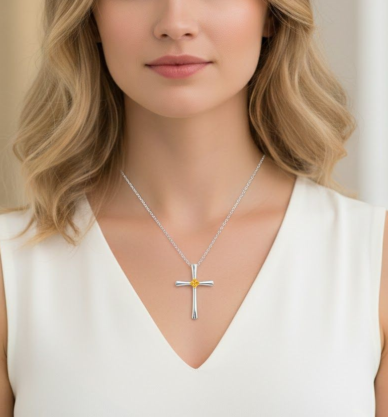 一個人戴著一條銀色十字架項鍊,中間有一個小小的金色裝飾,背景是純色的。