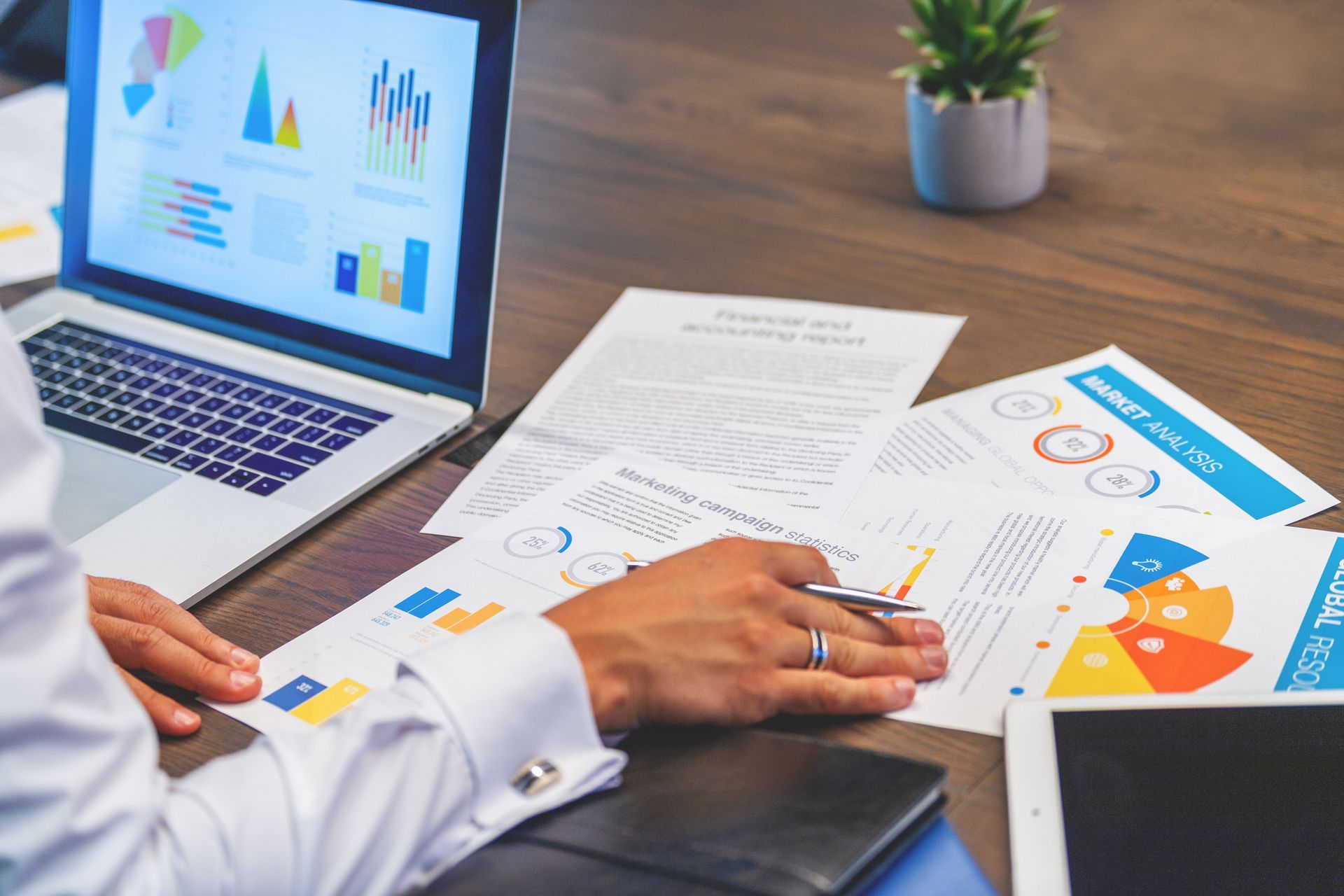 A man is sitting at a table with a laptop and papers.