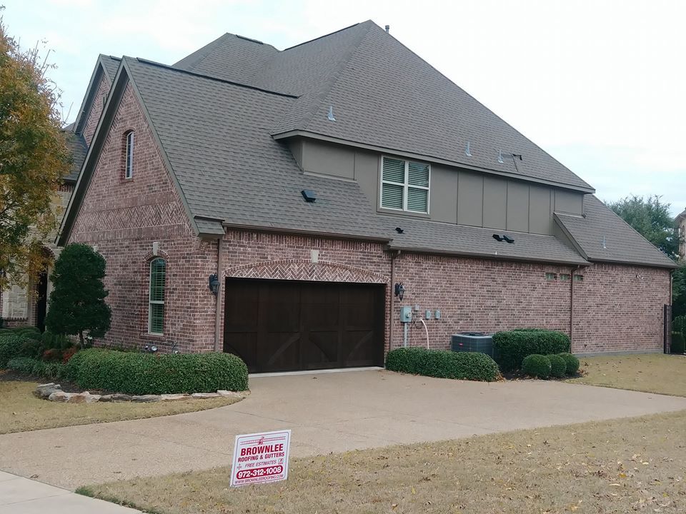 A large brick house with a brown garage door