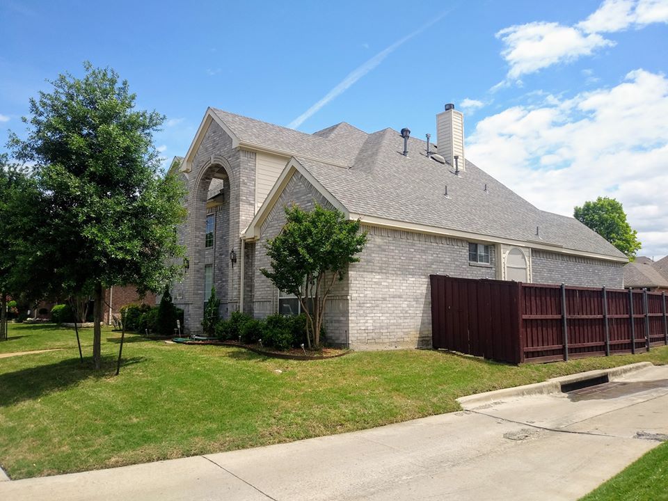 A large brick house with a fence in front of it