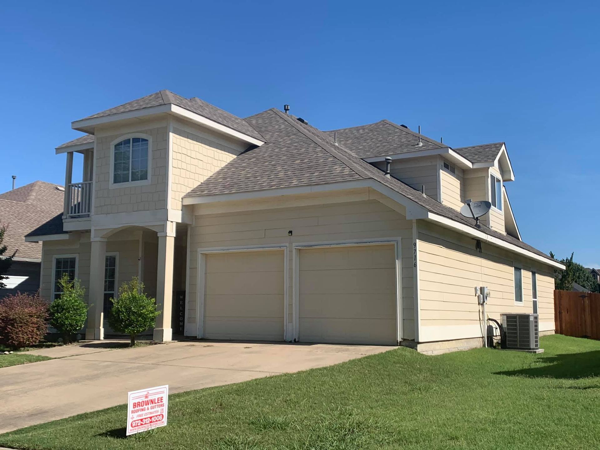A large house with a for sale sign in front of it.