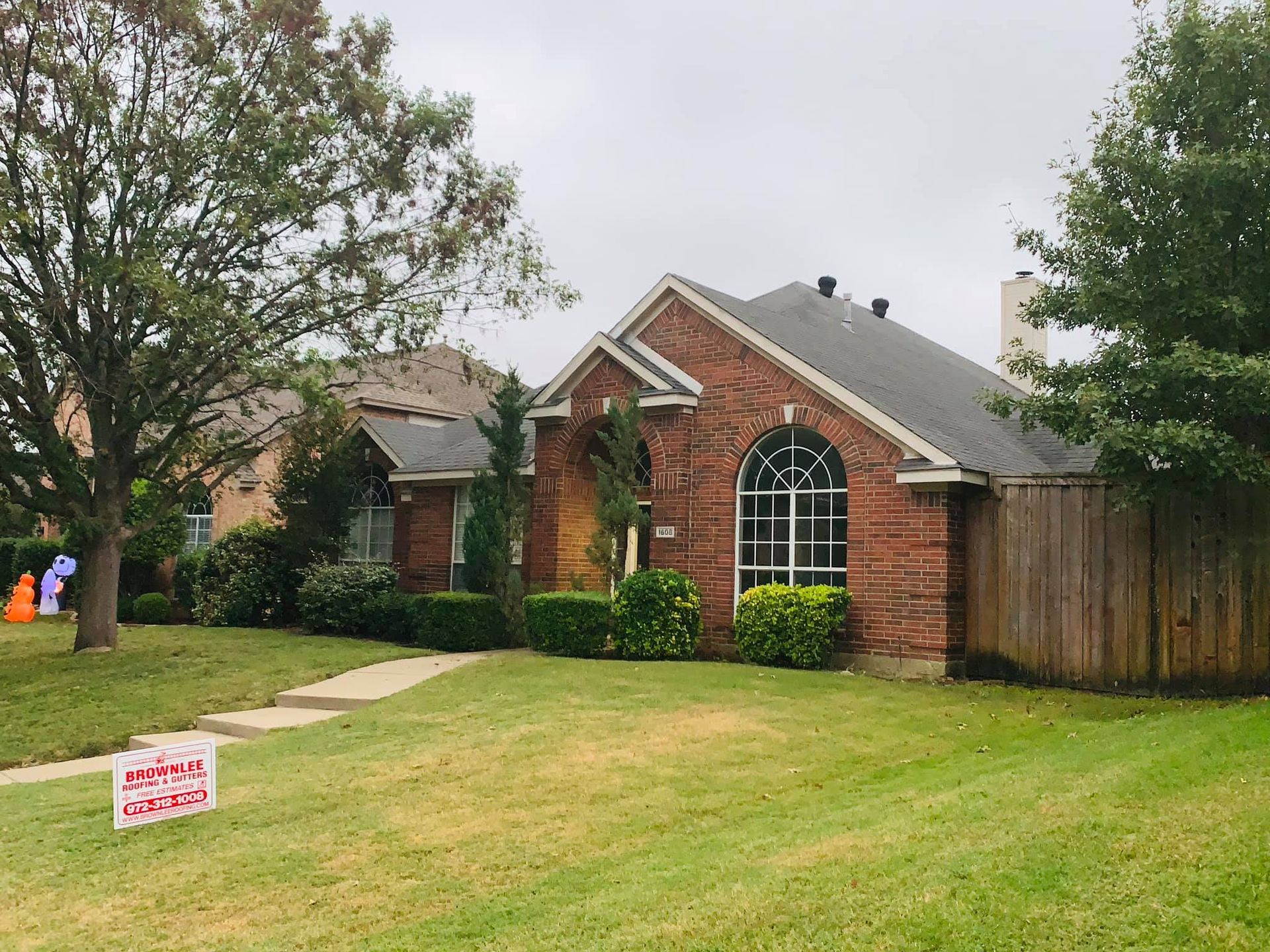 A brick house with a for sale sign in front of it