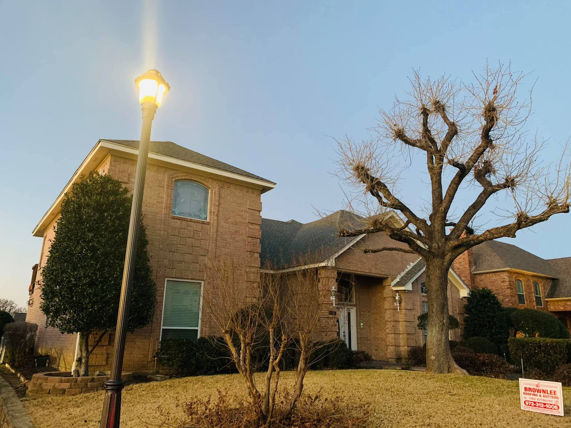 A brick house with a tree in front of it