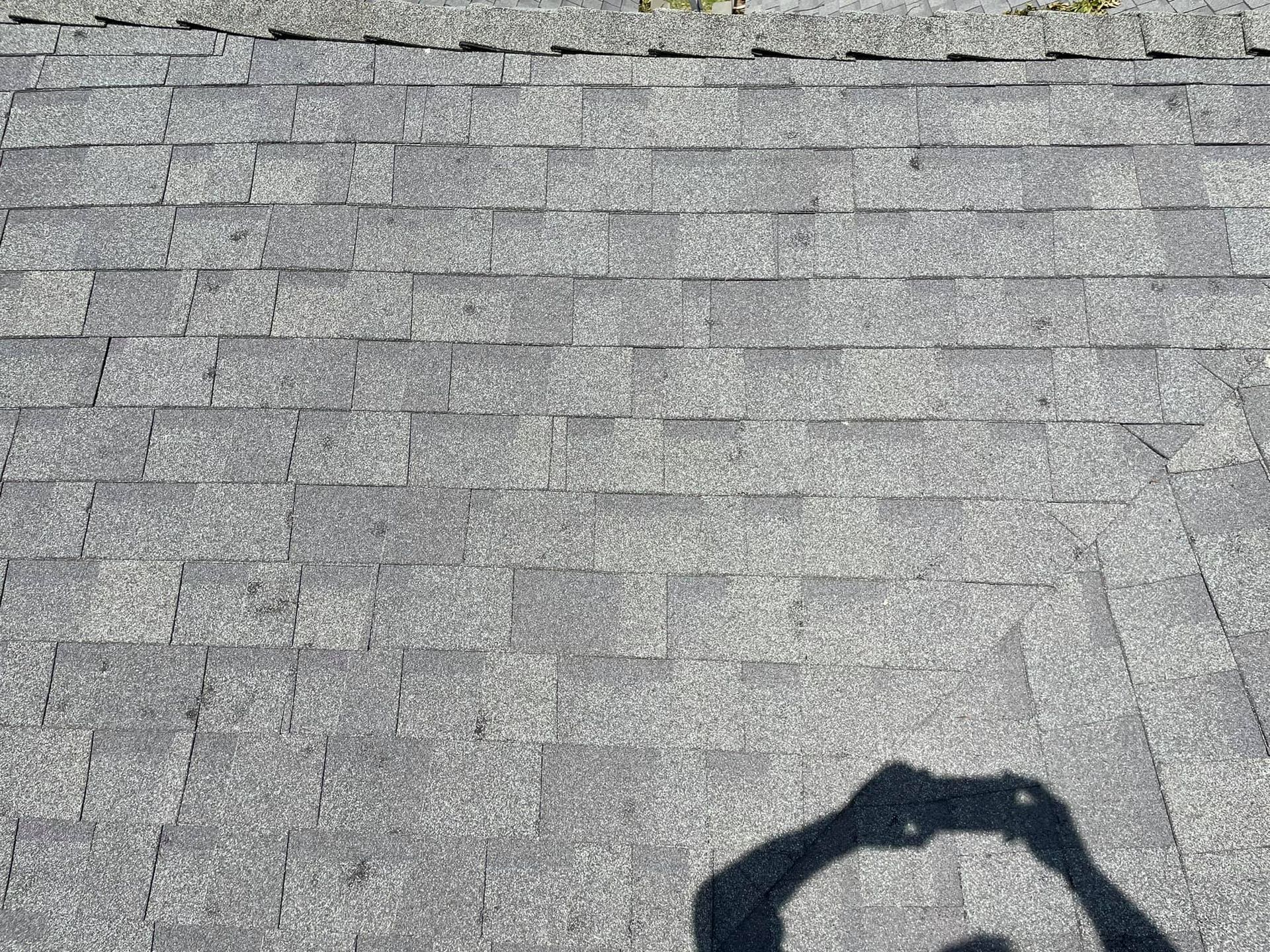 A person is taking a picture of their shadow on a roof.