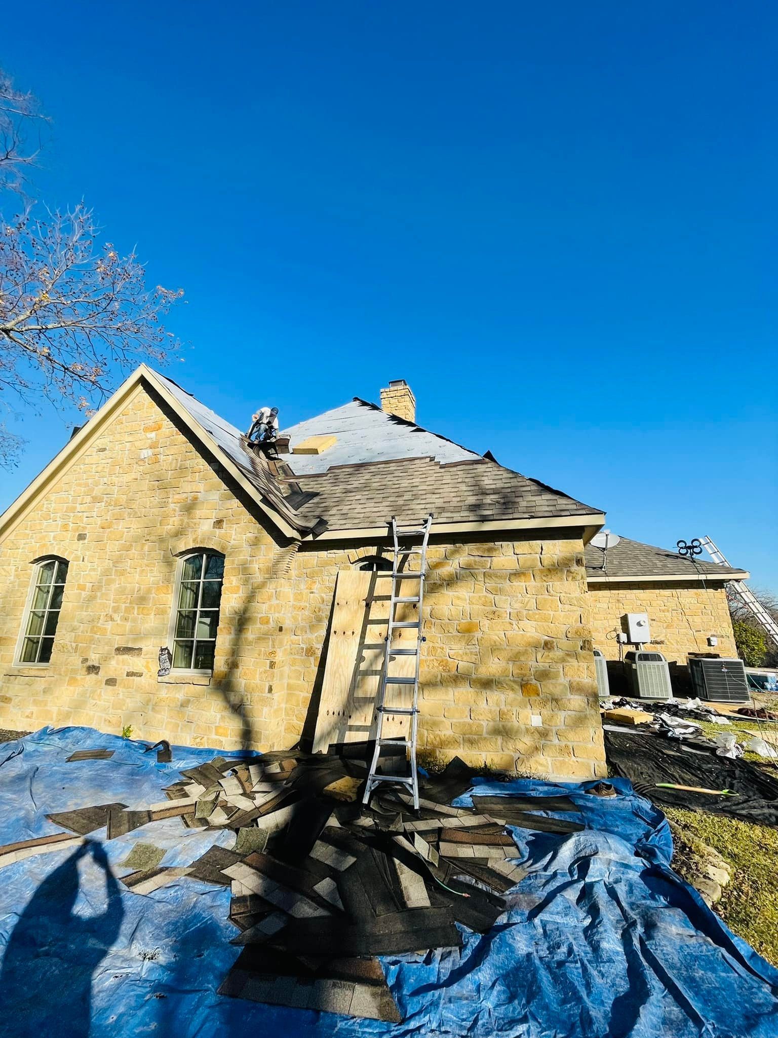 A man is working on the roof of a house.