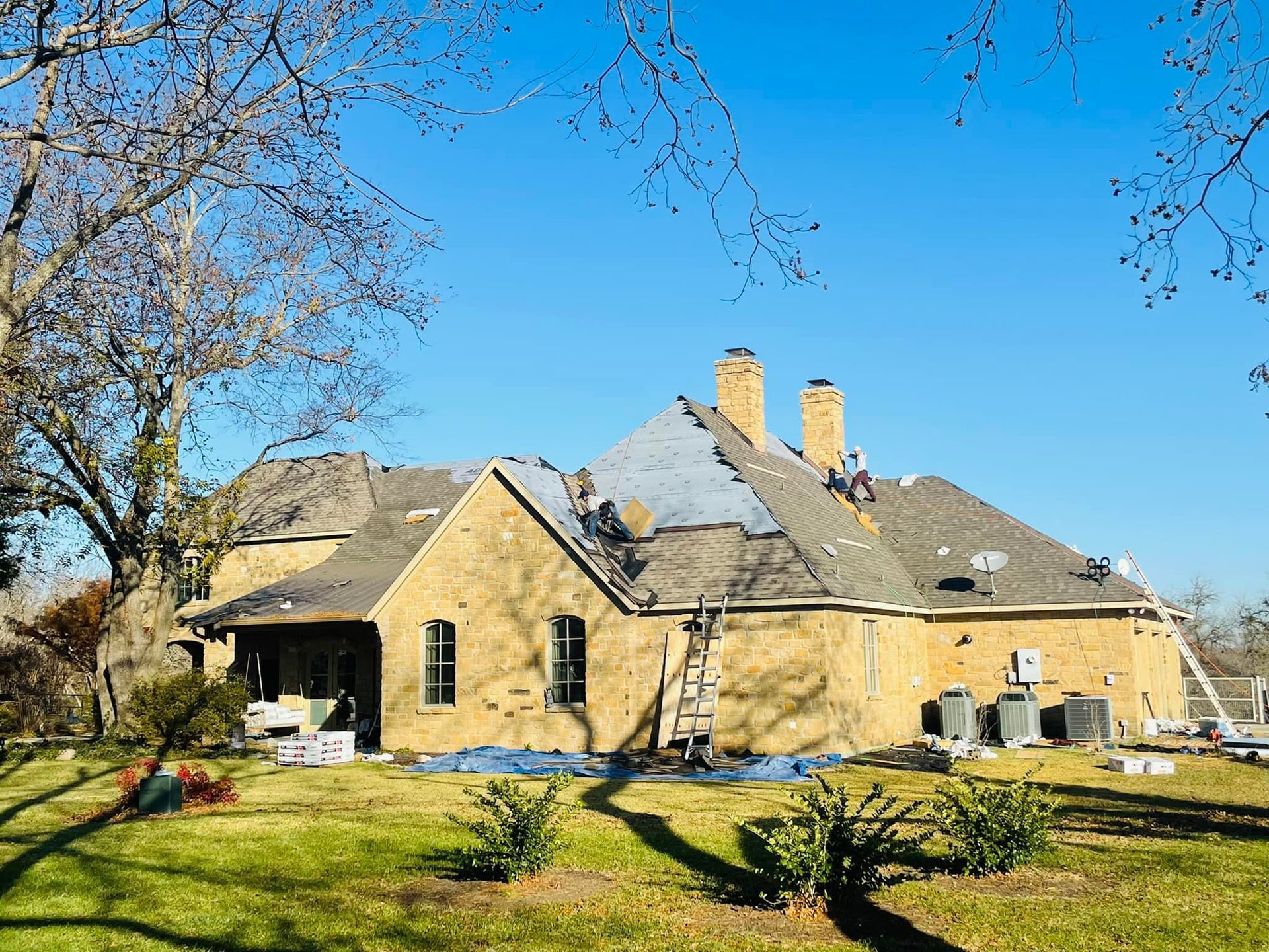 A large house is being remodeled with a roof being installed.