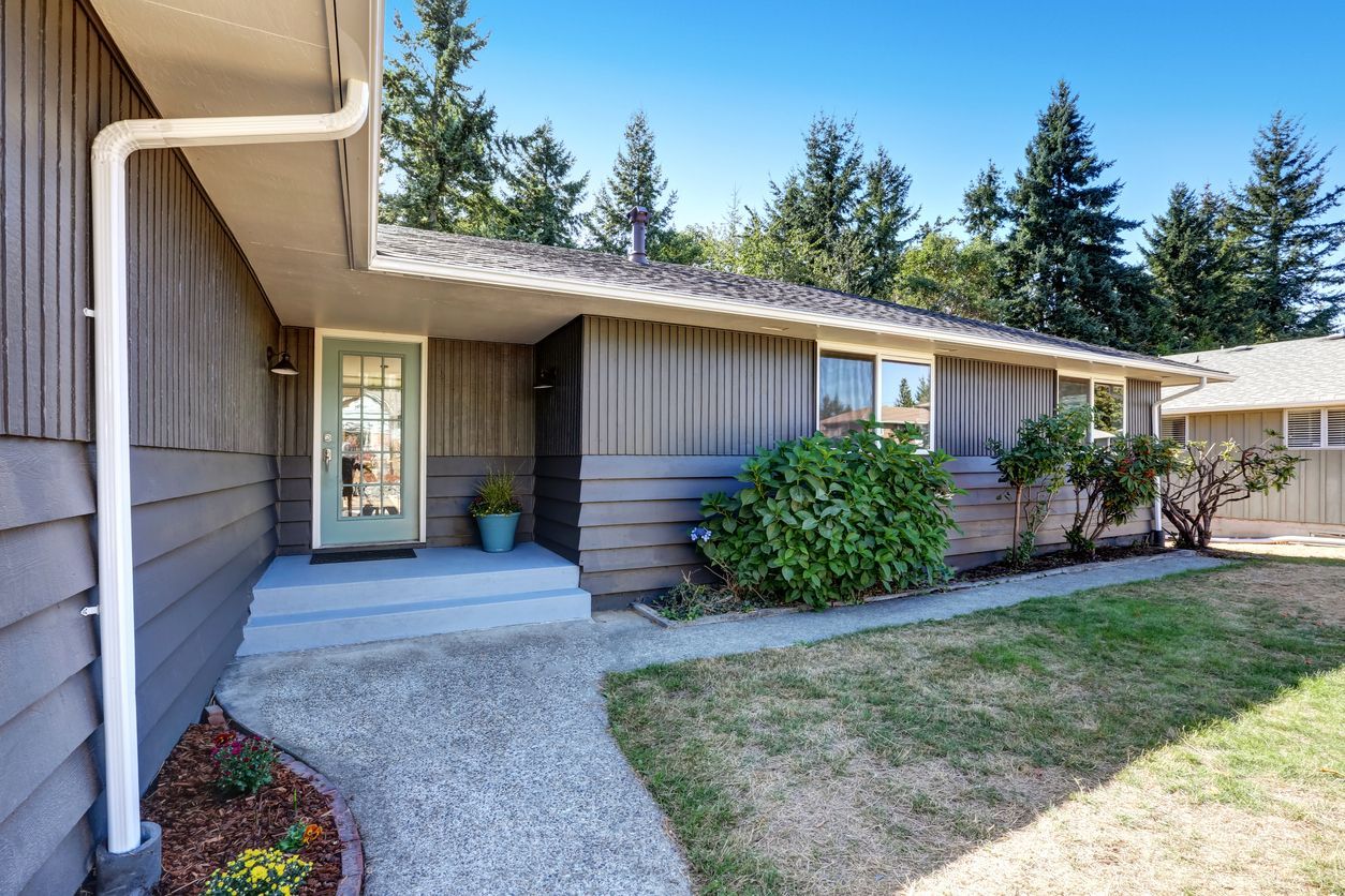 A house with a concrete walkway leading to the front door.