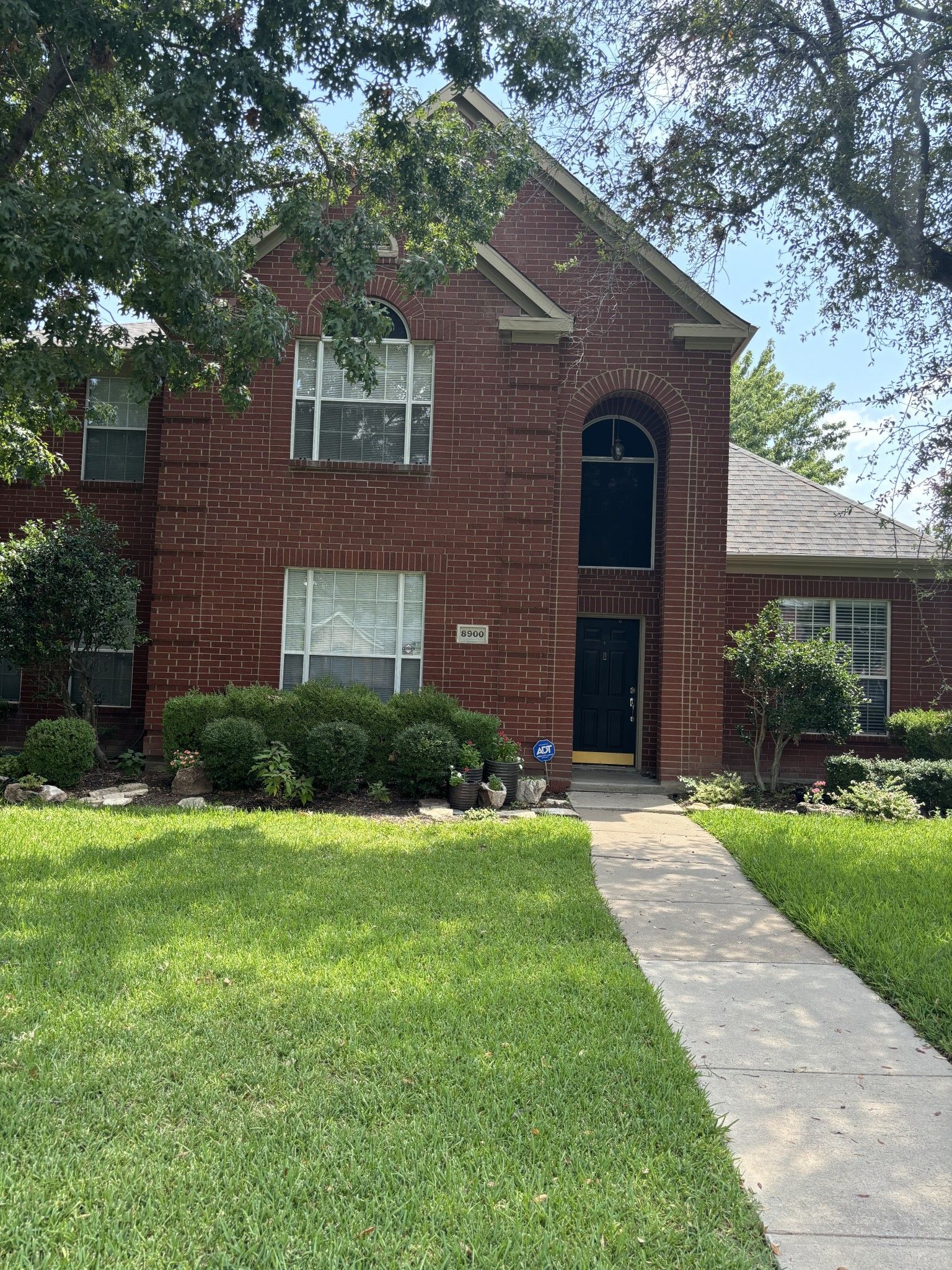A large brick house with a walkway leading to it