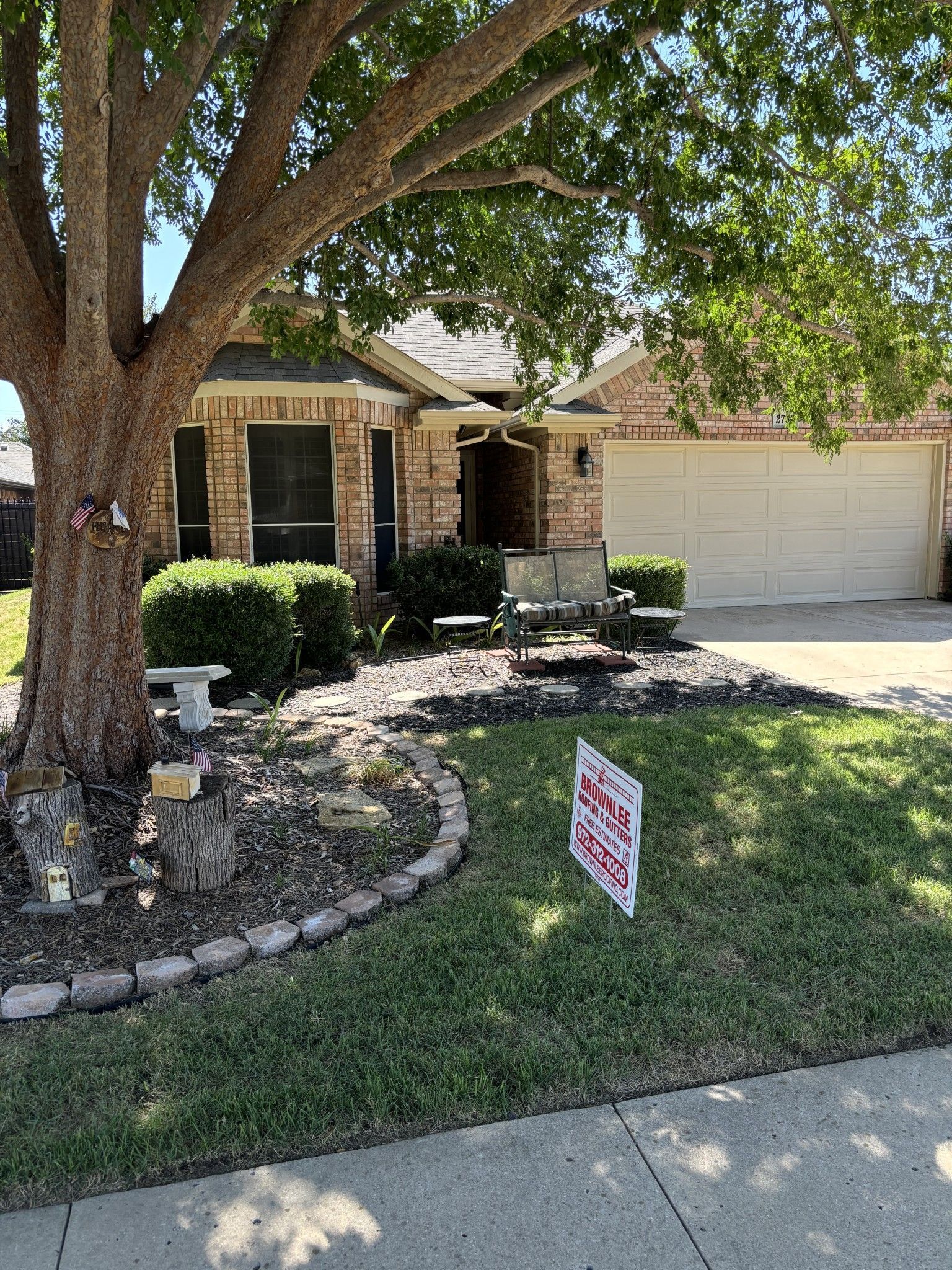 A house with a tree and a sign in front of it.