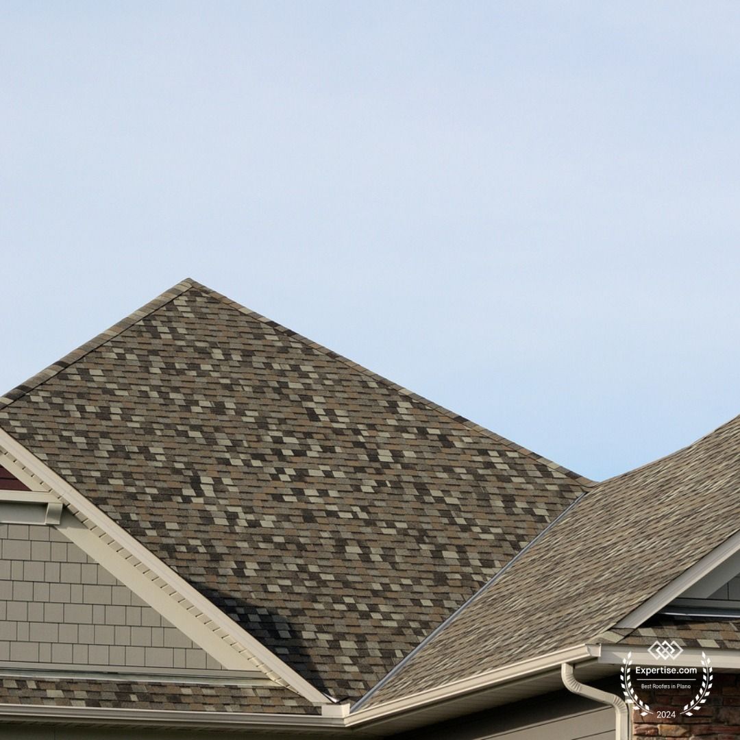 A house with a roof that has a roofing company logo on it