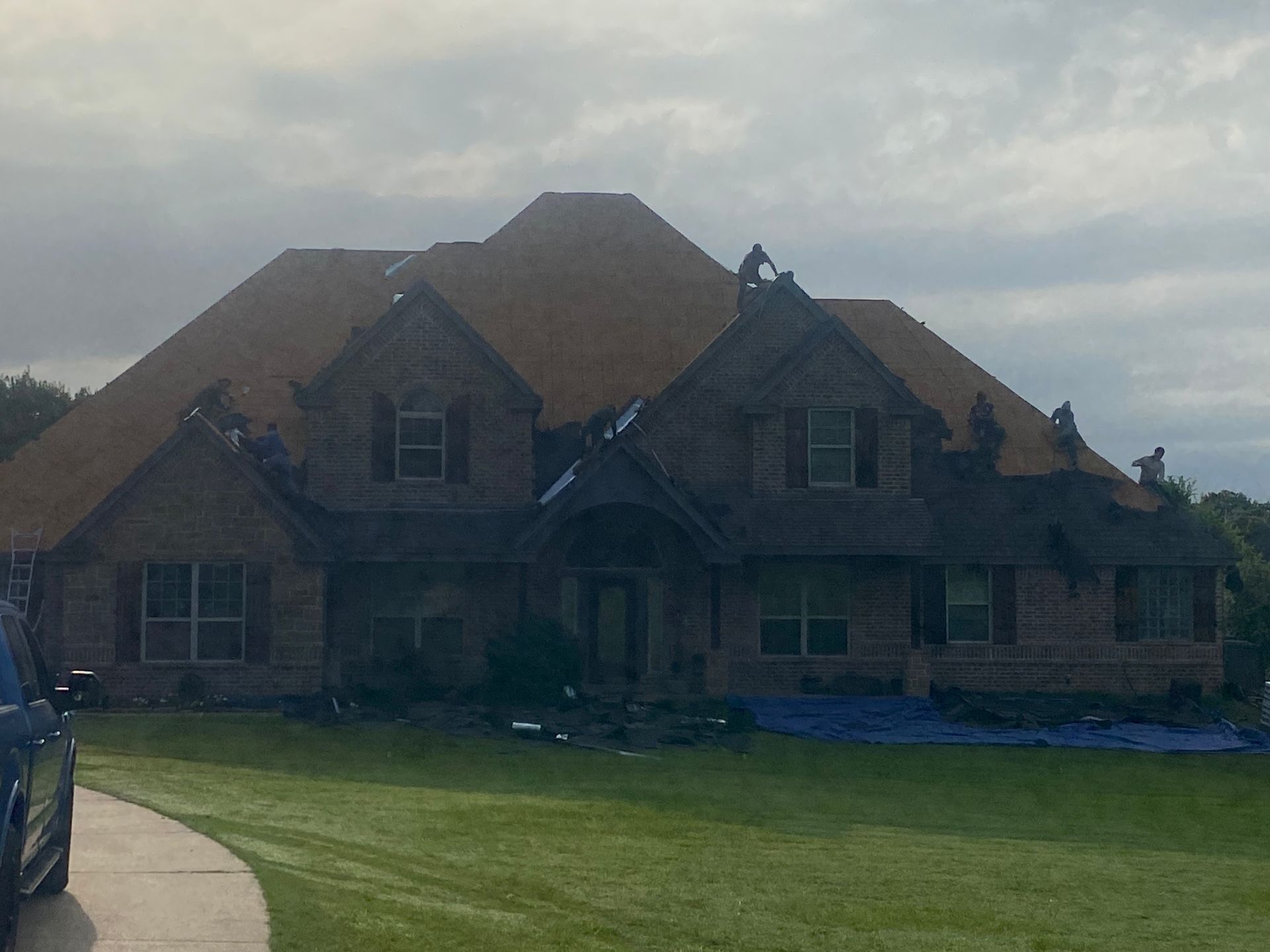 A large brick house with a car parked in front of it.