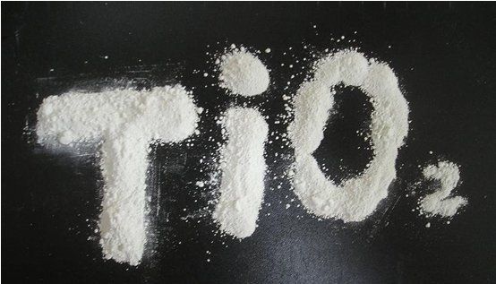 The word tio2 is written in white powder on a black surface.