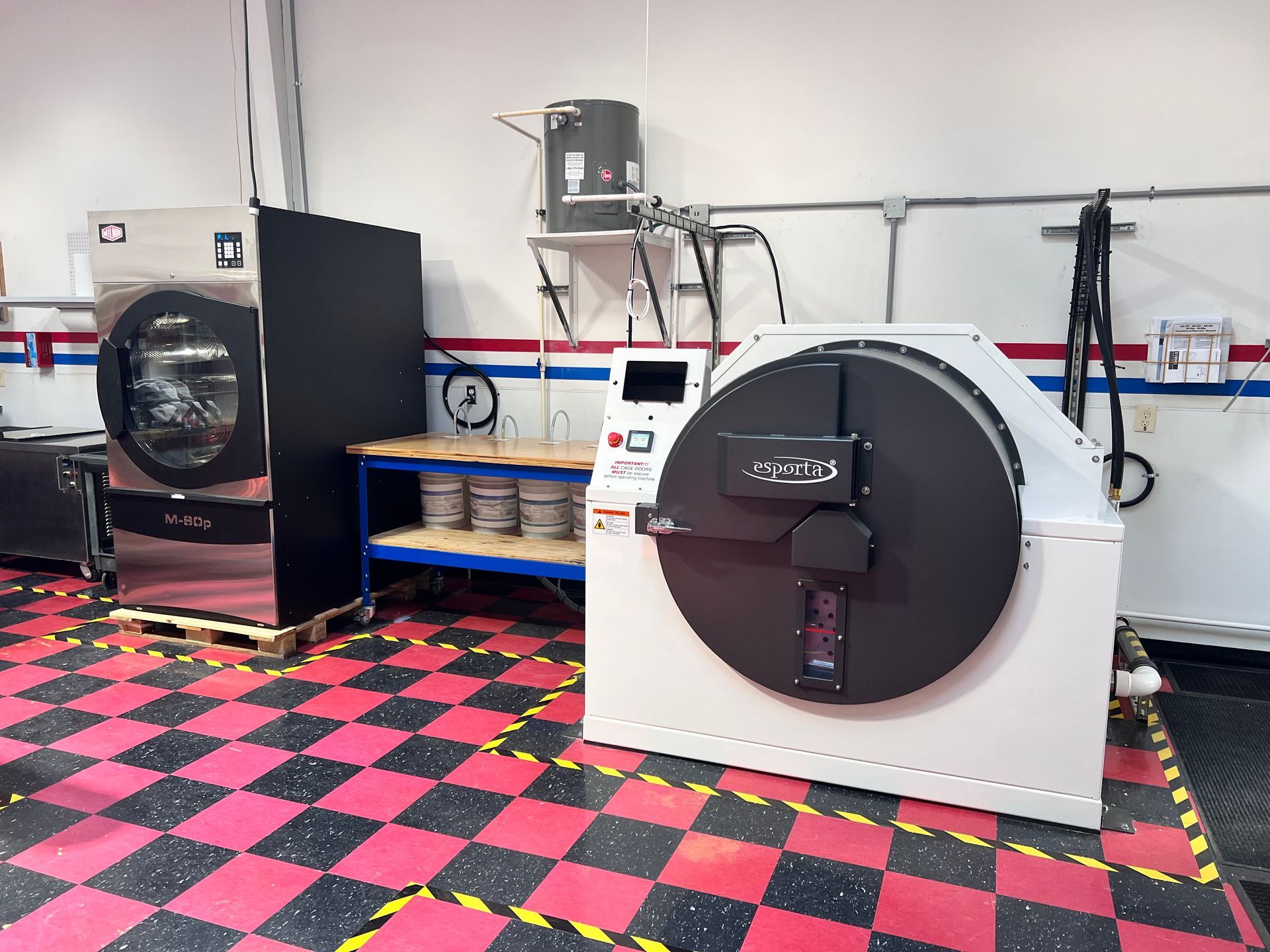 A lab with freeze dryers and equipment; red, black, and white checkerboard flooring.
