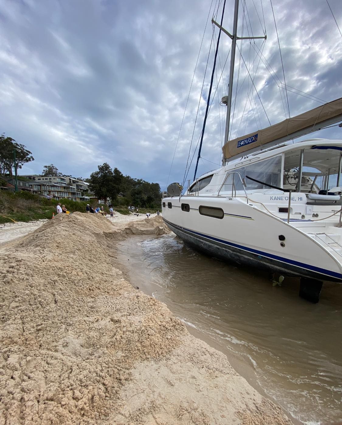 A Sailboat Beached on Sand, Waves Lapping at Its Hull — M&J Marine Services in Forster, NSW