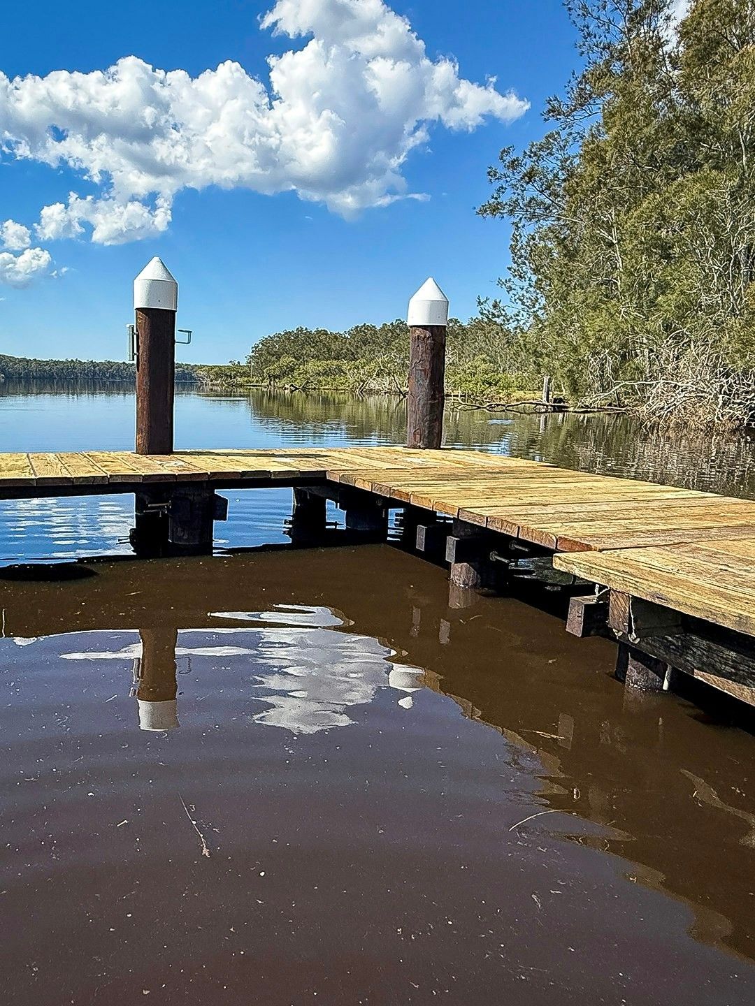 Wooden Dock on Dark Water with White-Topped Posts — M&J Marine Services in Lake Macquarie, NSW