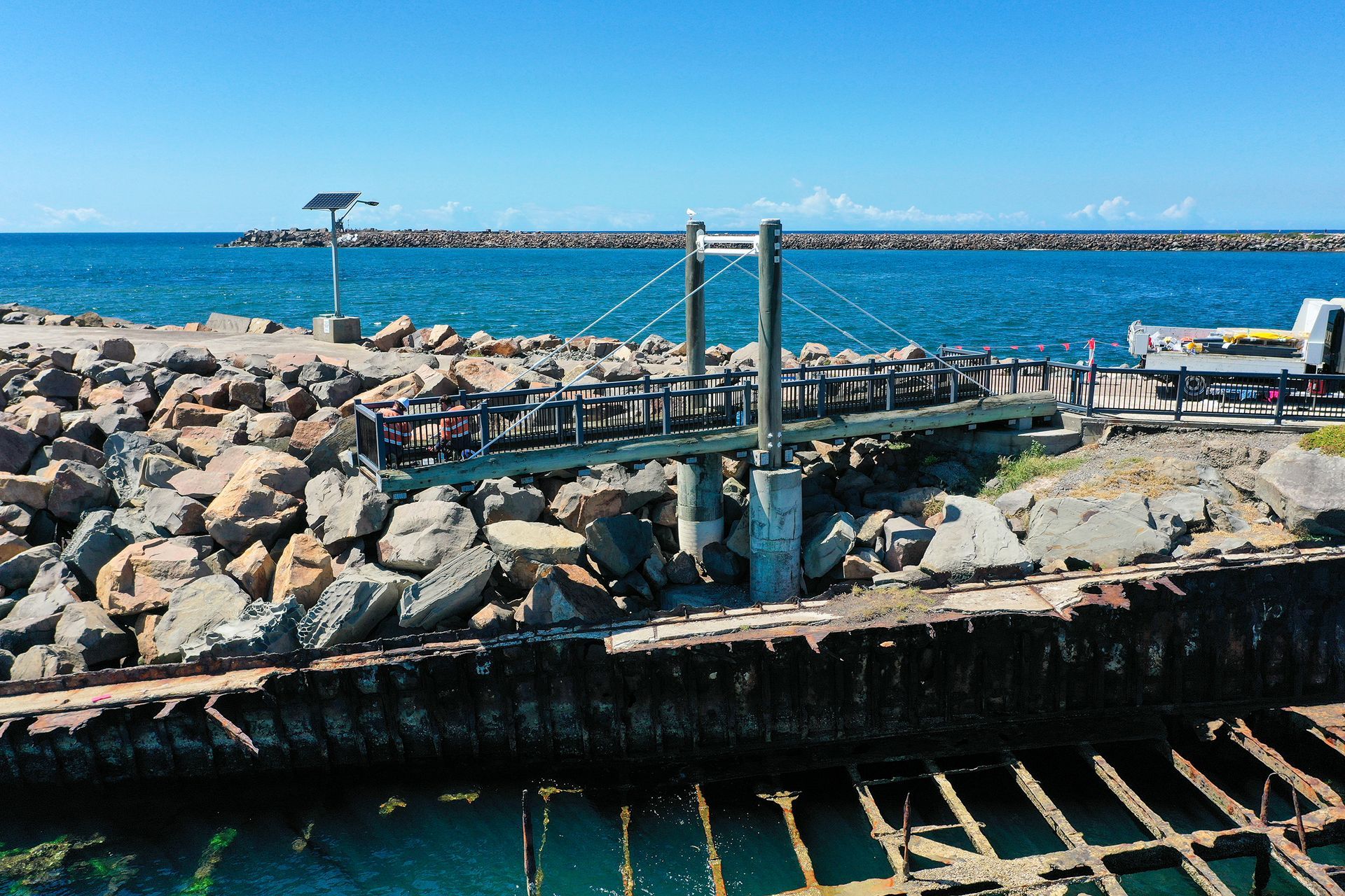 A Small Pedestrian Suspension Bridge Connects a Rocky Breakwater to A Pier — M&J Marine Services in Forster, NSW