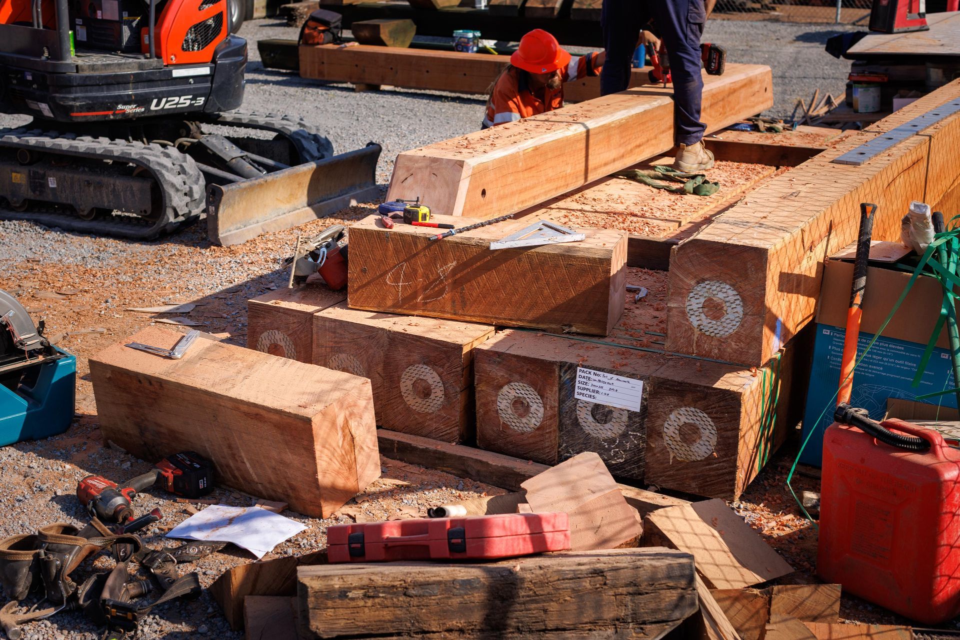 A Construction Site Features Workers Preparing Large Wooden Beams — M&J Marine Services in Lake Macquarie, NSW