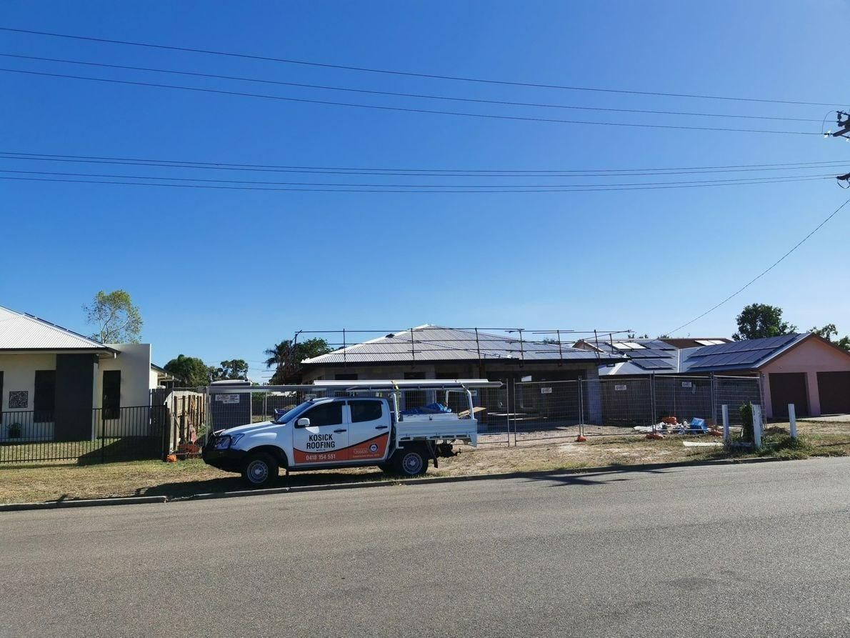 A White Truck Is Parked In Front Of A House Under Construction — Kosick Roofing NQ Pty Ltd In Mount Low, QLD