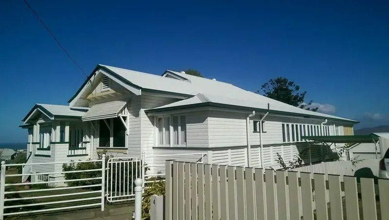 A White House With A White Fence And A Blue Sky In The Background — Kosick Roofing NQ Pty Ltd In Mount Low, QLD