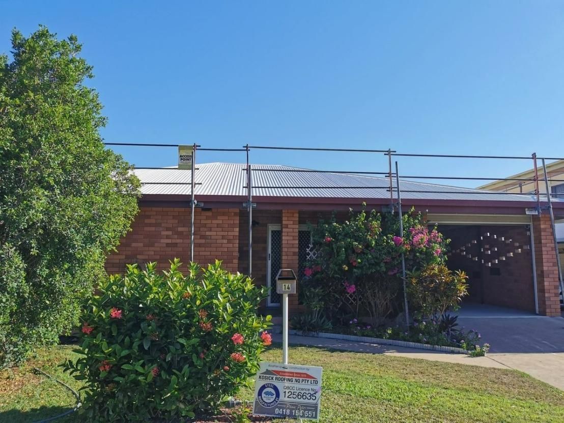 A Brick House With Scaffolding On The Roof And A Sign In Front Of It — Kosick Roofing NQ Pty Ltd In Mount Low, QLD