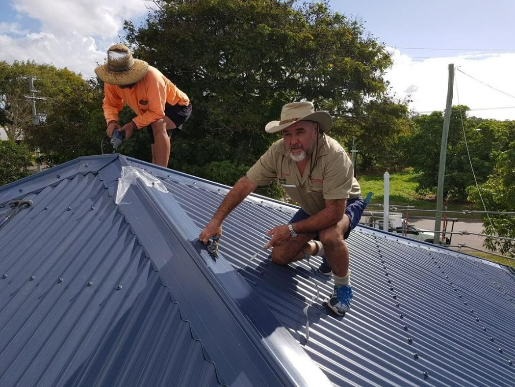 Two Men Are Working On The Roof Of A House — Kosick Roofing NQ Pty Ltd In Mount Low, QLD