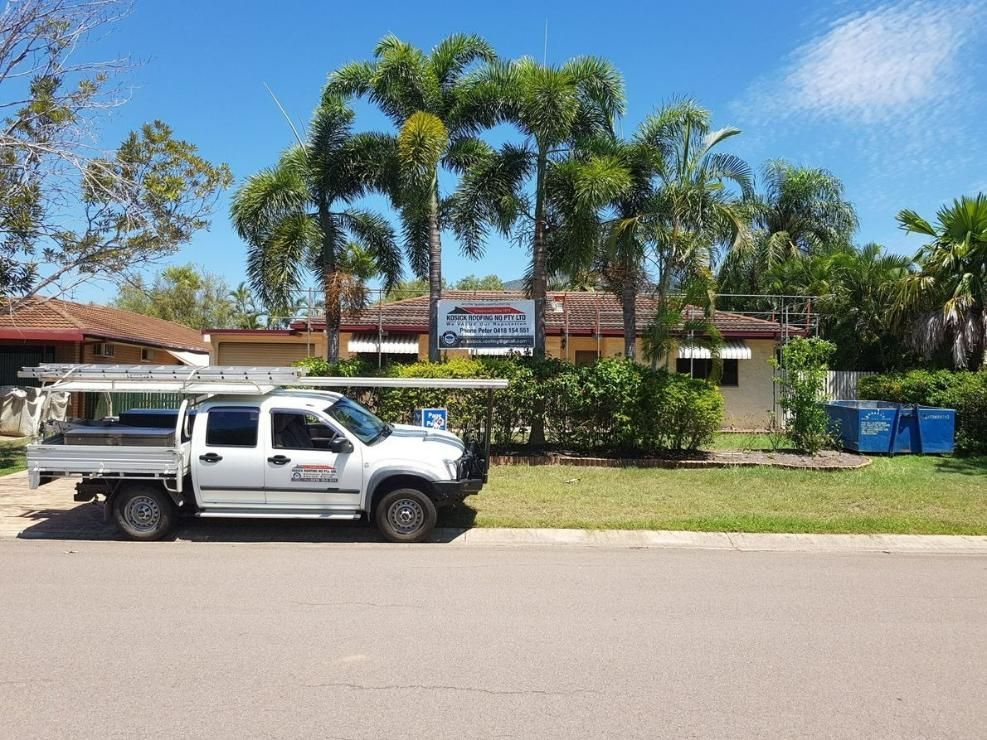 A White Truck Is Parked On The Side Of The Road In Front Of A House — Kosick Roofing NQ Pty Ltd In Mount Low, QLD