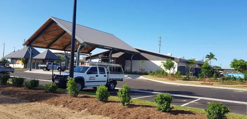 A White Truck Is Parked Under A Canopy In Front Of A Building — Kosick Roofing NQ Pty Ltd In Mount Low, QLD