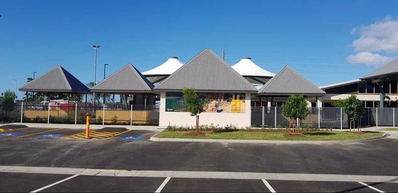 A Parking Lot In Front Of A Building With A Pyramid Shaped Roof — Kosick Roofing NQ Pty Ltd In Mount Low, QLD