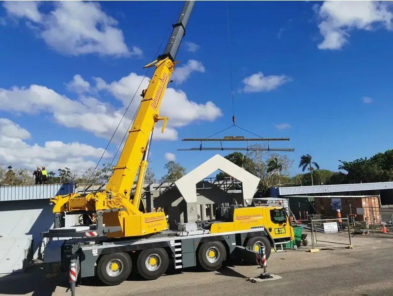A Large Yellow Truck With A Crane Attached To It — Kosick Roofing NQ Pty Ltd In Mount Low, QLD