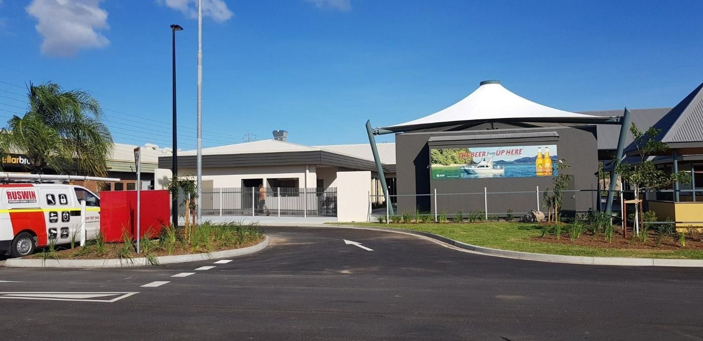 An Ambulance Is Parked On The Side Of The Road In Front Of A Building — Kosick Roofing NQ Pty Ltd In Mount Low, QLD