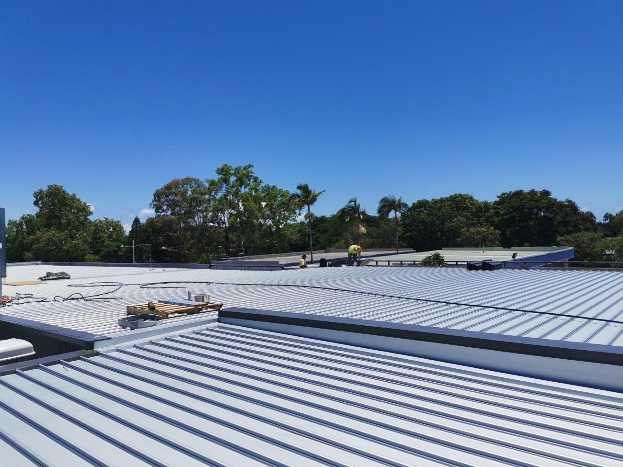 A Large White Roof With A Blue Sky In The Background — Kosick Roofing NQ Pty Ltd In Mount Low, QLD