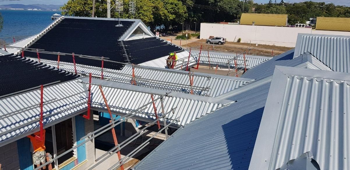 An Aerial View Of A Building Under Construction With Scaffolding On The Roof — Kosick Roofing NQ Pty Ltd In Mount Low, QLD