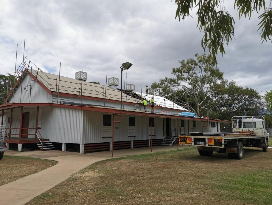 A Truck Is Parked In Front Of A Building Under Construction — Kosick Roofing NQ Pty Ltd In Mount Low, QLD