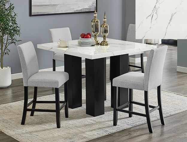 A dining room table and chairs are sitting on a rug.