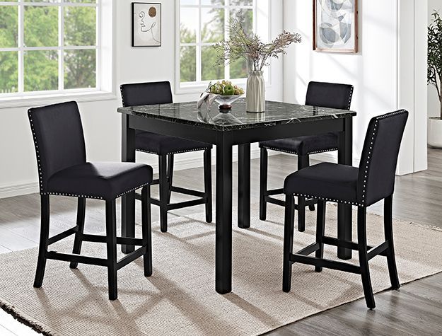 A dining room table and chairs are sitting on a rug in front of a window.