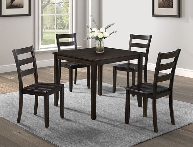 A dining room table with four chairs and a vase of flowers on it.