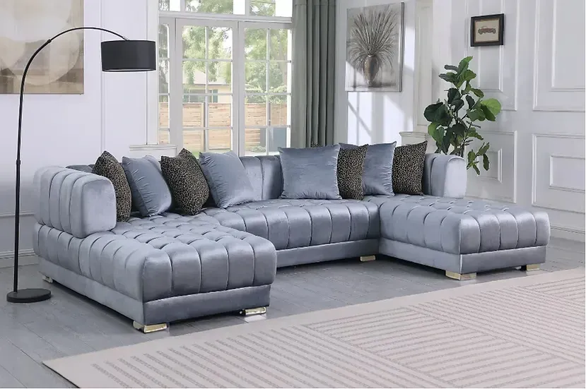 A living room with a large sectional couch and a lamp