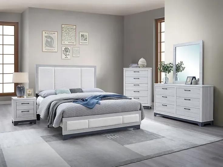 A bedroom with a bed , dresser , nightstand and mirror.