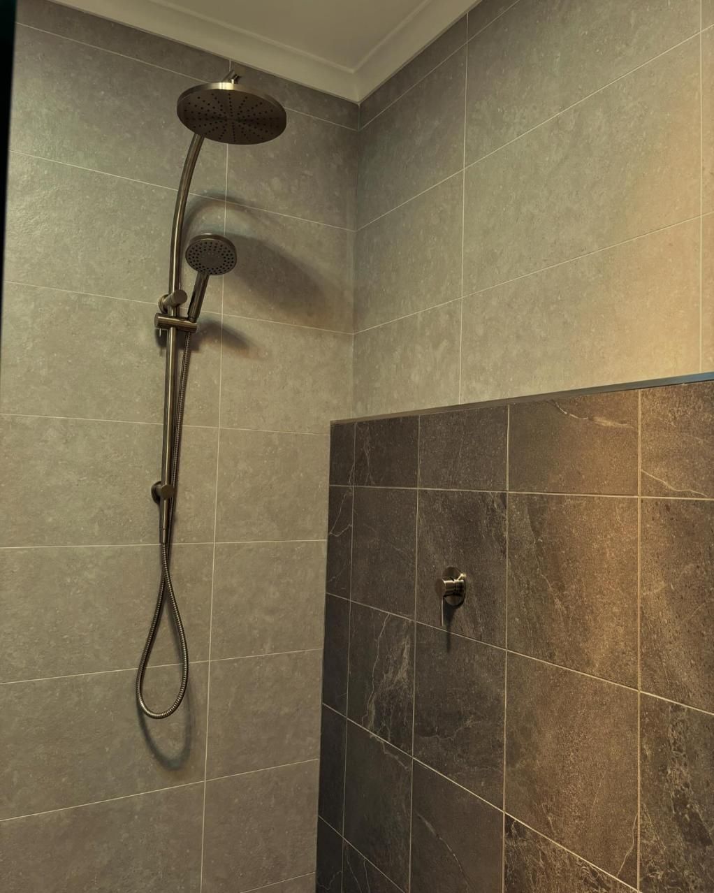 A Shower Head Is Hanging From The Ceiling In A Bathroom — Oceanforce Plumbing In Blacksmiths, NSW